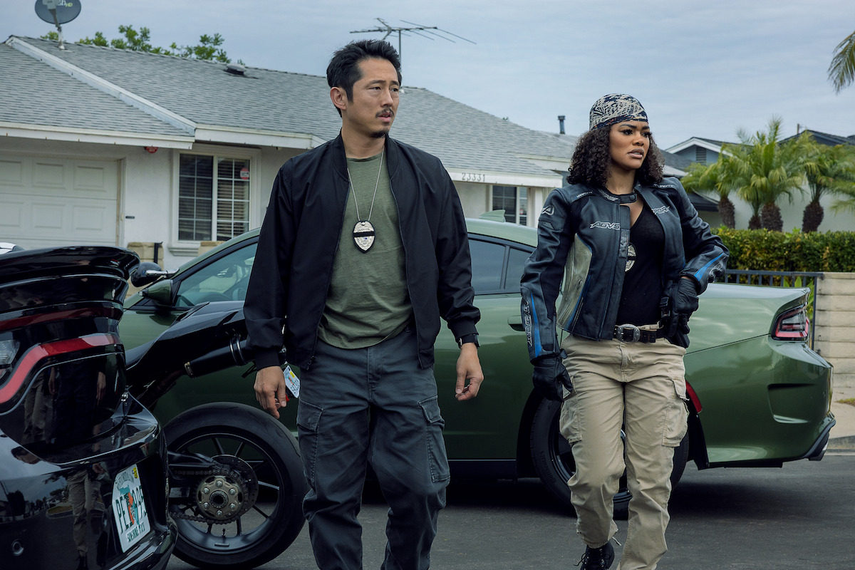 Steven Yeun as Detective Mike Ro and Teyana Taylor as Detective Numa Baptiste in The Rip. Cr. Warrick Page/Netflix