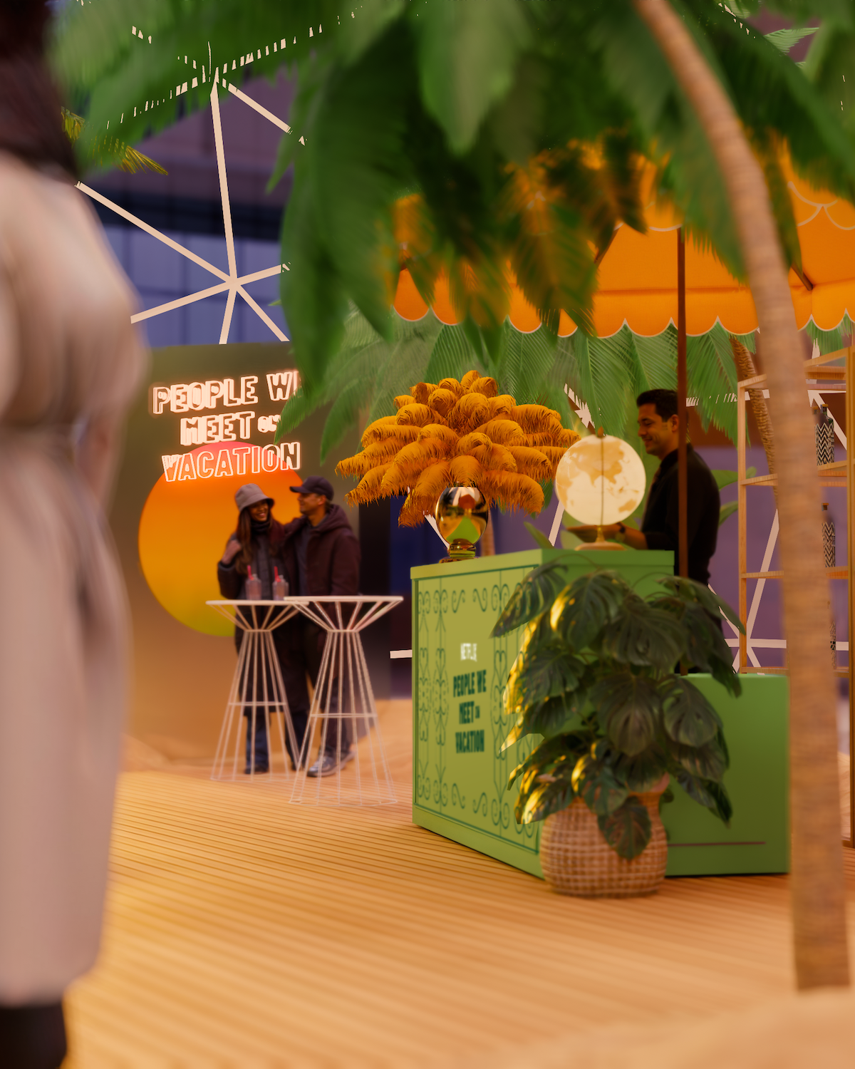 People socializing in a tropical-themed indoor setting with palm trees, colorful decor, a green booth, neon sign reading "People We Meet On Vacation," and cozy gathering under an orange canopy.