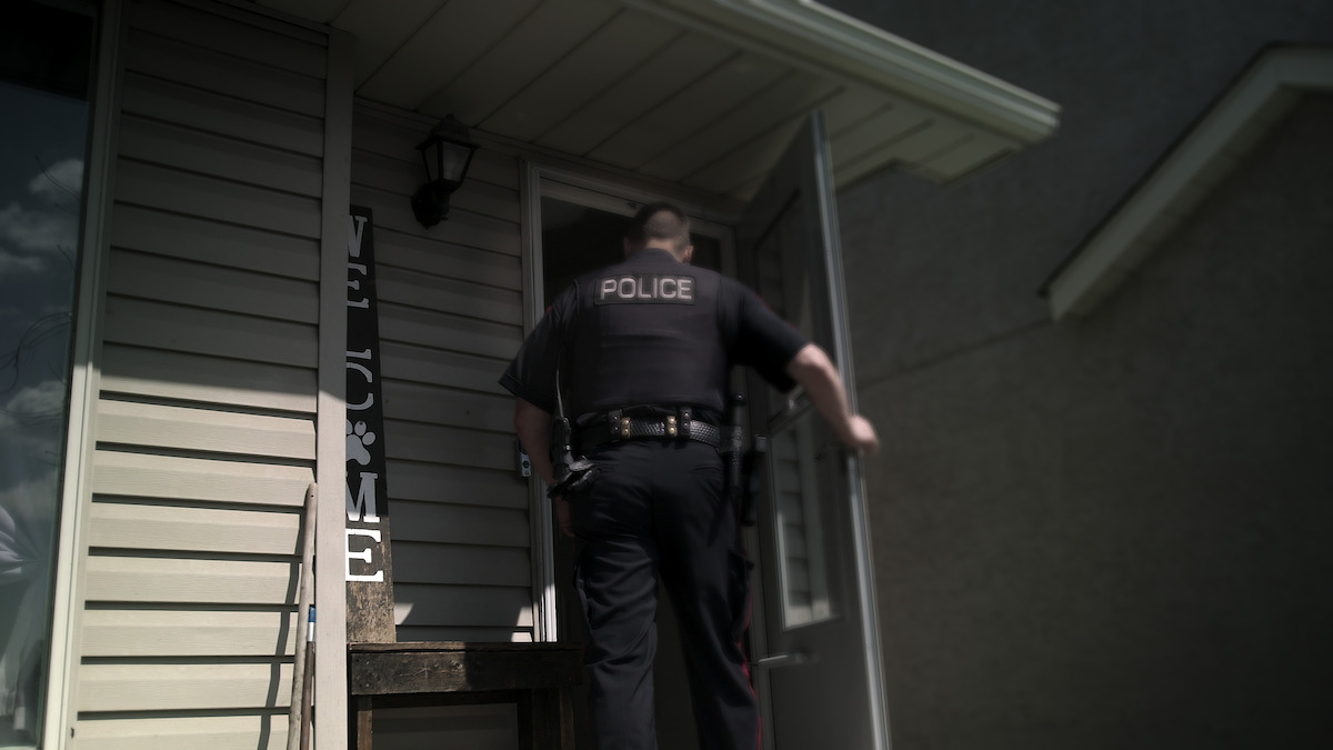 A police officer enters a home.
