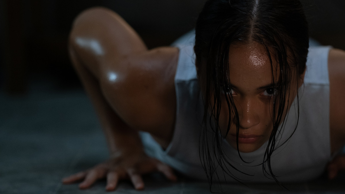 Aurora Ribero as 13 pushes against the floor with her hands as she lies on the floor in an image from the film ‘The Shadow Strays.’