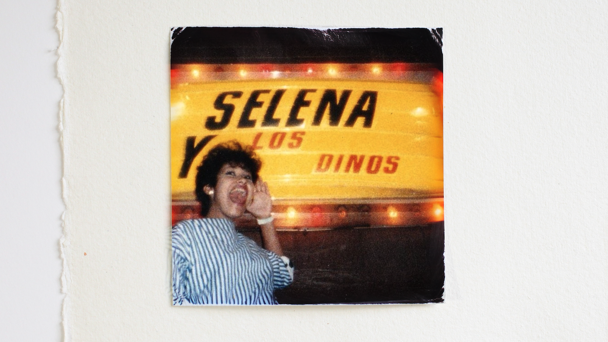 Selena posing in front of a Selena Y Los Dinos marquee