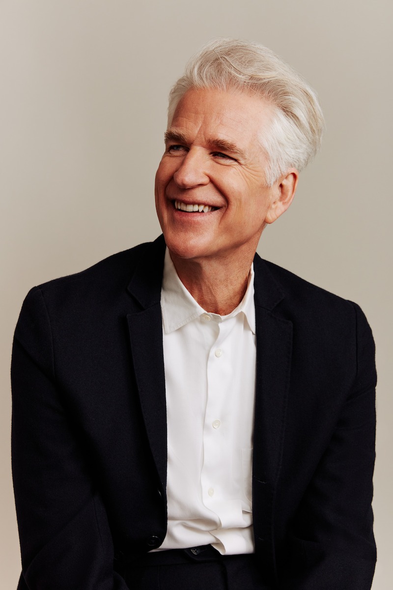 Matthew Modine seated and smiling - See Millie Bobby Brown and Matthew Modine’s ‘Stranger Things’ Cover Shoot Photos 