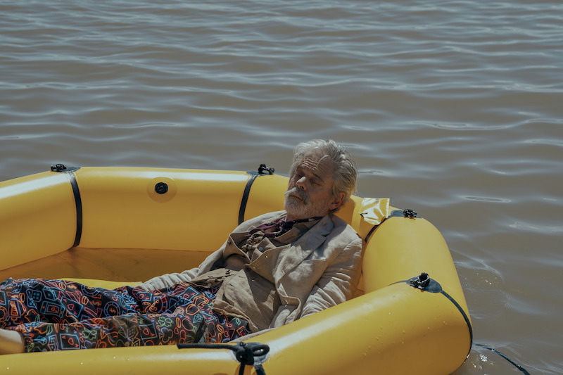 C. Thomas Howell as Haggerty in Obliterated in a yellow raft in the middle of a lake. 