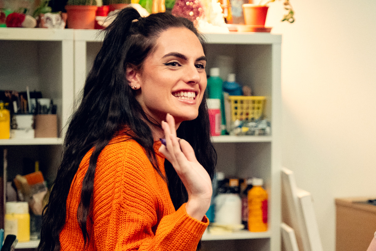 Bel Priestley as Naomi waves and smiles in Season 3 of ‘Heartstopper.’