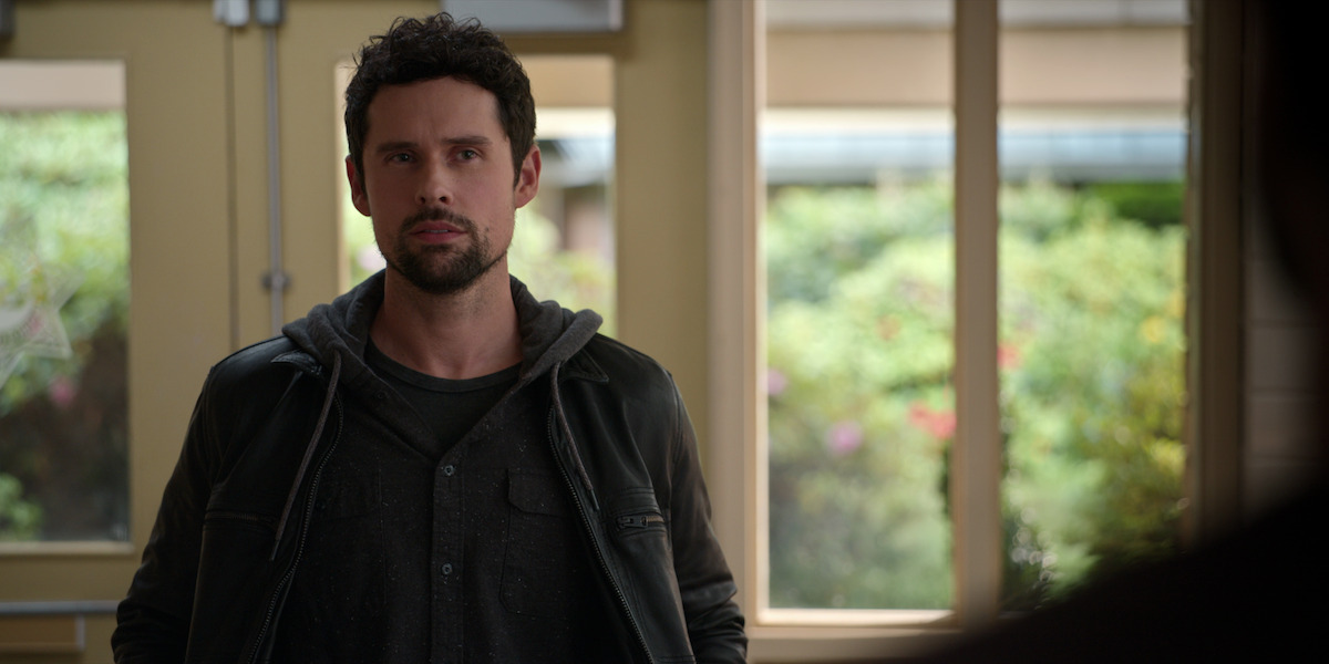 Benjamin Hollingsworth looks at someone with a skeptical expression, wearing a zip up hoodie.