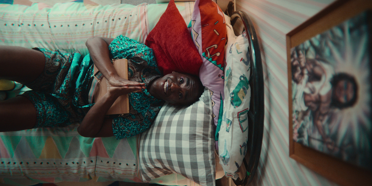 Ncuti Gatwa as Eric lies on his bed looking up at a framed picture of Jesus in Season 4 of ‘Sex Education.’