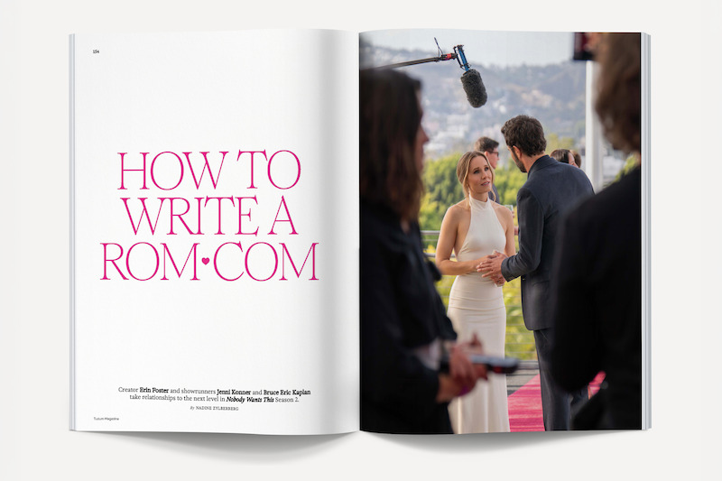 Magazine spread with the left page titled "How To Write A Rom-Com" in pink font, and the right page showing a film set where a woman in a white dress and a man converse on a red carpet, with crew and boom mic visible.