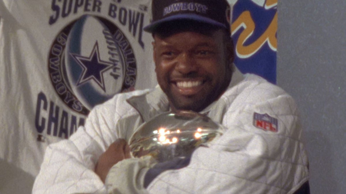 Emmitt Smith holding the Vince Lombardi Trophy.