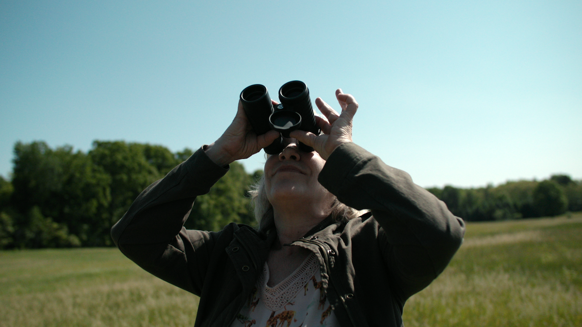 Cathy Terkanian using binoculars.