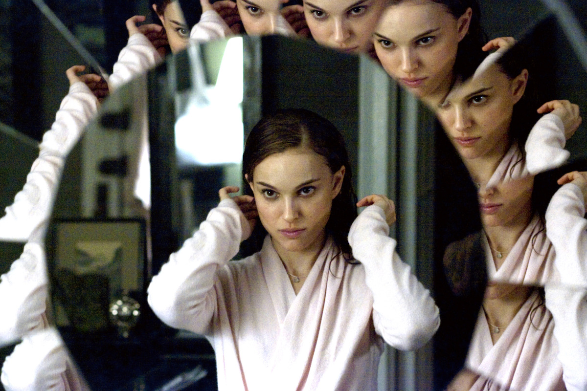Natalie Portman sits in front of a vanity with a circular mirror in ‘Black Swan’