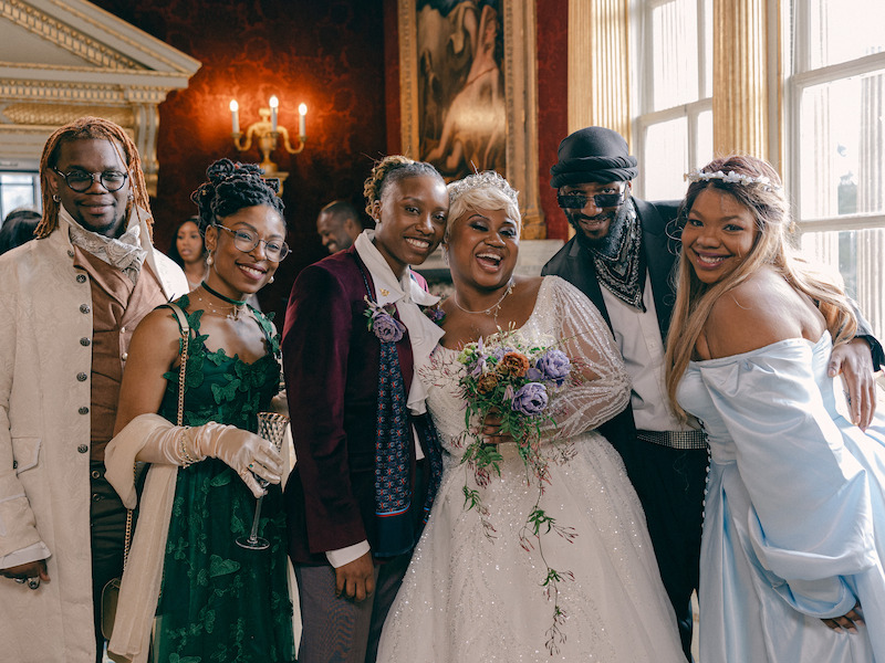 A group shot of the couple and guests in 'The Event of the Season: A Bridgerton Wedding'