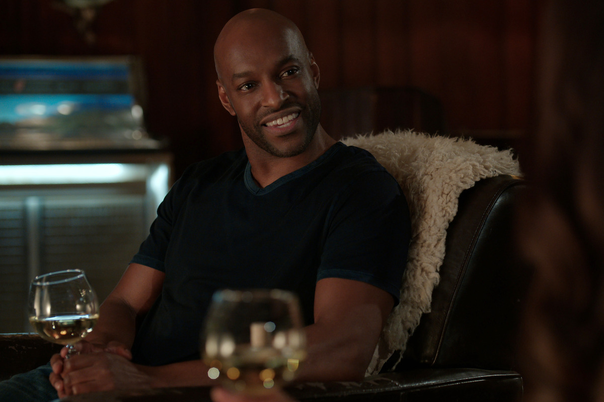 Colin Lawrence as John “Preacher” Middleton sits in a bar in Season 5 of ‘Virgin River.’