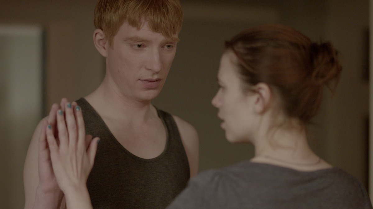 A man and woman face each other and touch palms in Season 2 of 'Black Mirror'