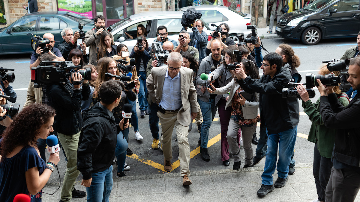 Tristán Ulloa as Alfonso walks through a crowd of photographers in season 1 of ‘The Asunta Case’