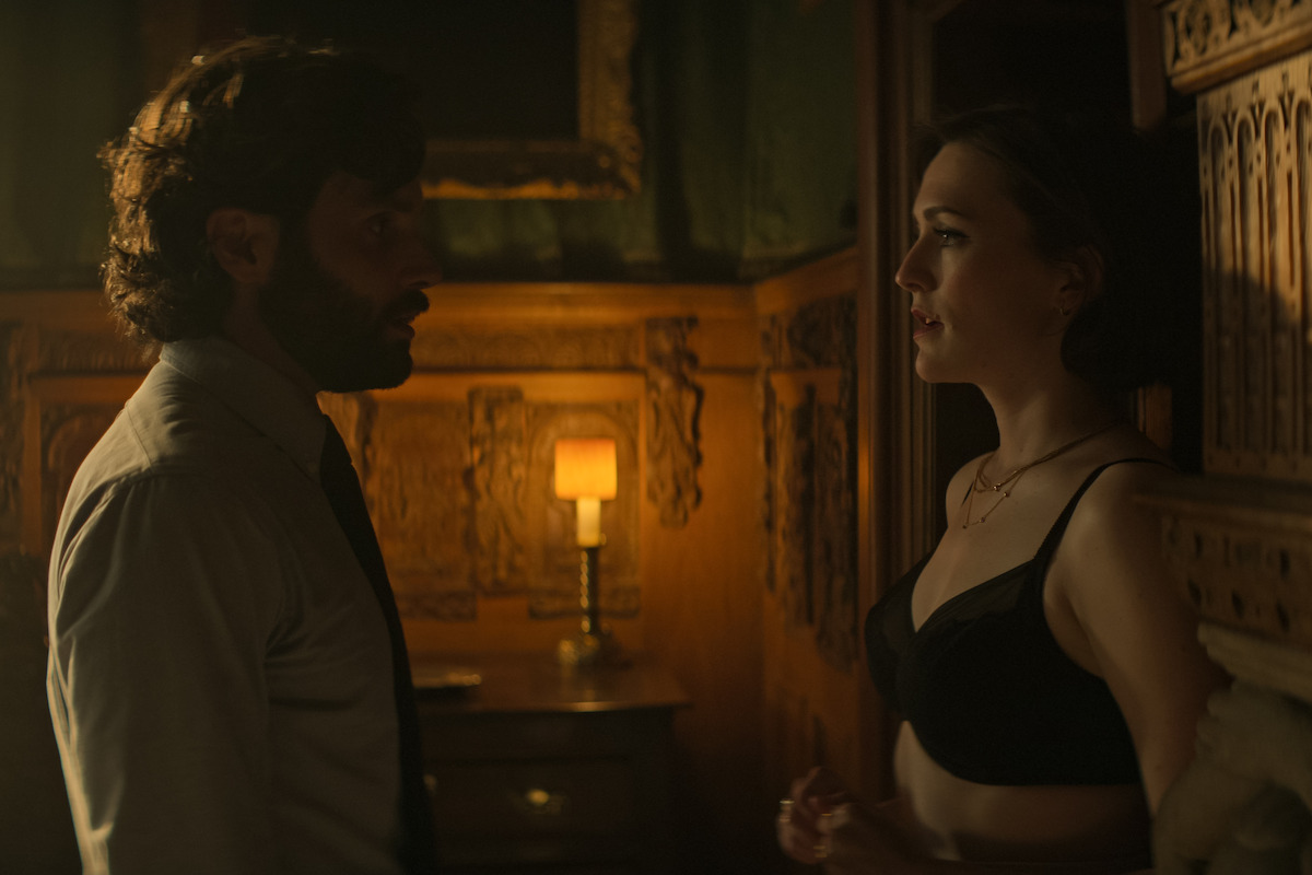 Penn Badgley and Charlotte Ritchie share a passionate look as Joe and Kate.