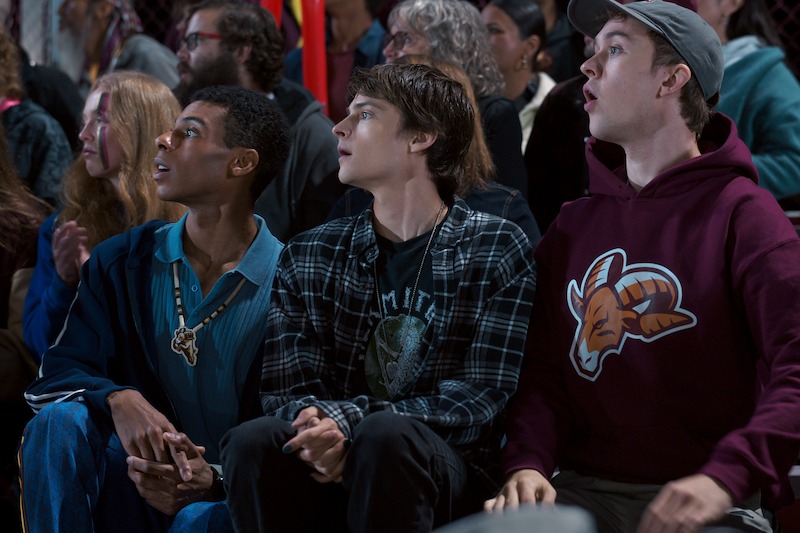 Jaylan Evans as Skylar, Corey Fogelmanis as Nathan, and Connor Stanhope as Danny sitting in a crowd in 'My Life with the Walter Boys' Season 2