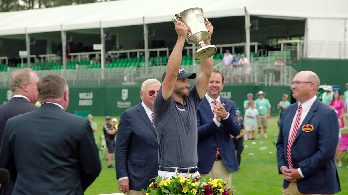 Wyndham Clark lifts a trophy.