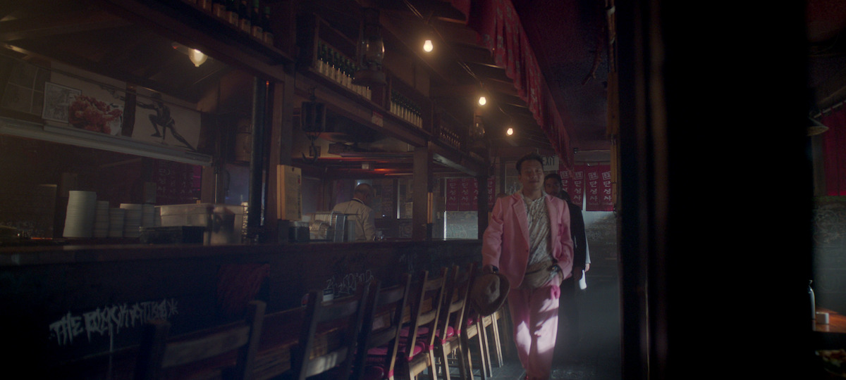 Joon Lee as TK Lee walks through a Korean BBQ restaurant in season 1 of ‘The Brothers Sun’