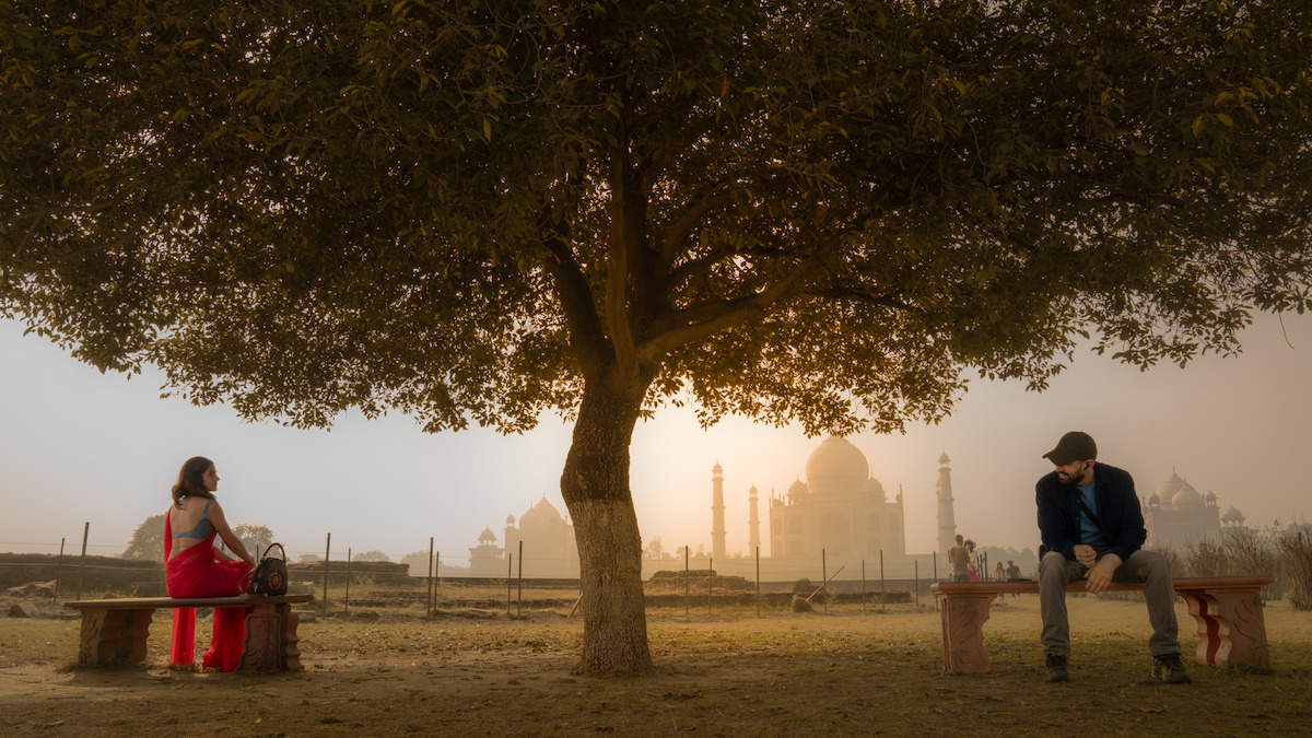 Taapsee Pannu as Rani and Vikrant Massey as Rishu sit on benches on either side of a large tree in an image from the film ‘Phir Aayi Hasseen Dillruba.’