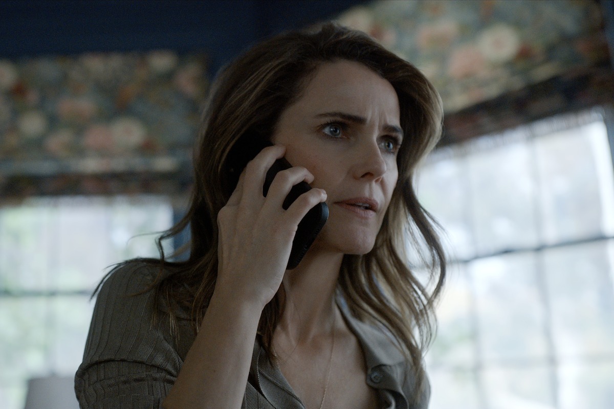 Keri Russell as Kate Wyler holds the phone to her ear and looks off into the distance with a worried expression on her face.