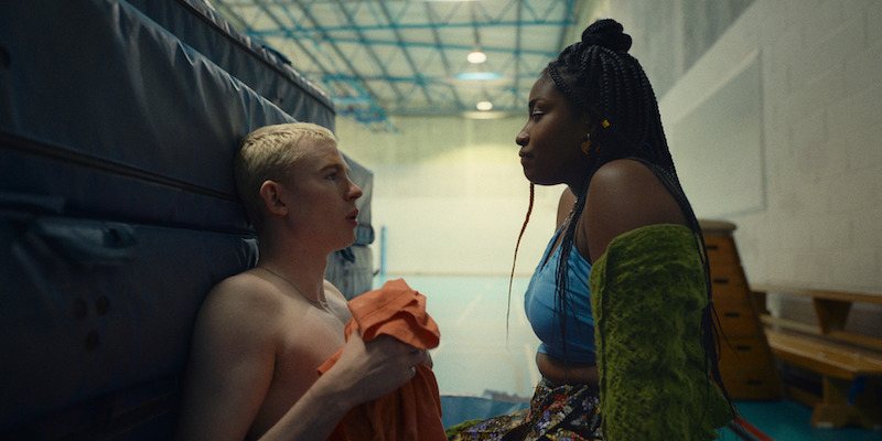 Harry Cadby as Cam and Lauryn Ajufo as Becca sit together hiding in a gym in Season 1 of 'Everything Now.'