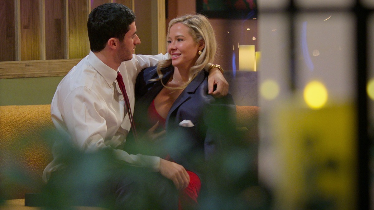 Leo puts his arm around Brittany on a couch after their reveal.