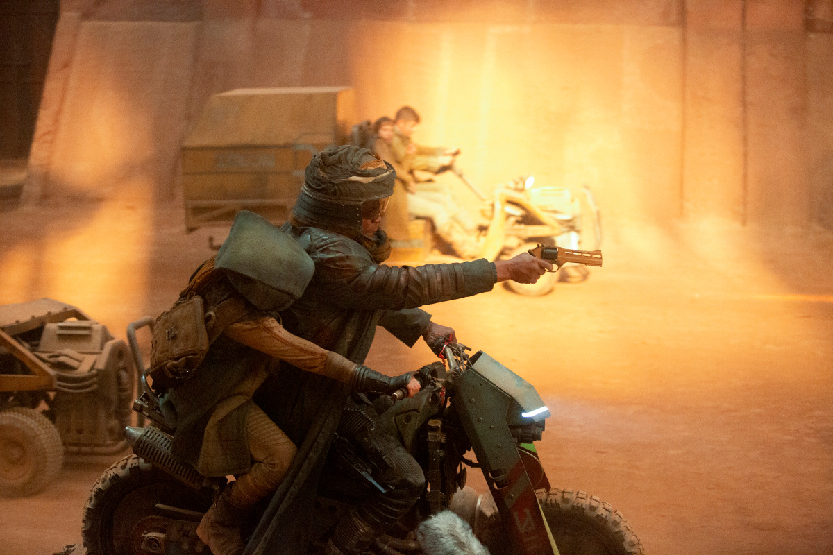 Yerin Ha as Kwan Ha and Bokeem Woodbine as Soren race through a dust storm on motorcycles in ‘Halo.’