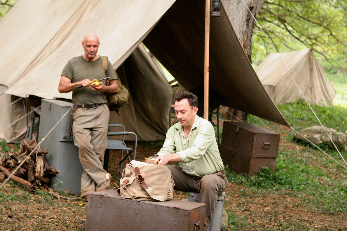 Terry O'Quinn cutting a fruit as Michael Emerson looks in his bag.
