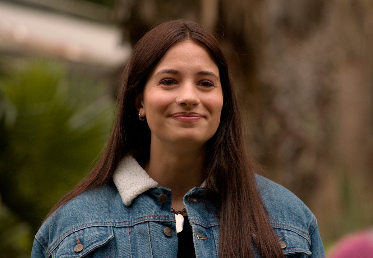 Mulher jovem de cabelos longos e castanhos sorri