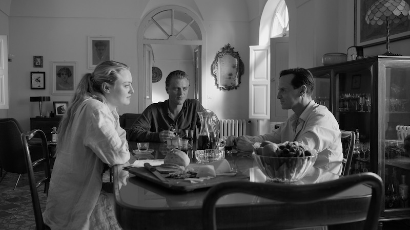 Dakota Fanning as Marge Sherwood, Johnny Flynn as Dickie Greenleaf, and Andrew Scott as Tom Ripley dine at a table together in ‘Ripley’