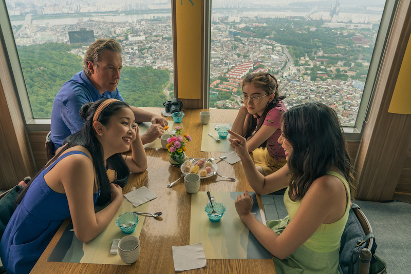 John Corbett as Dr Dan Covey, Lana Condor as Lara Jean Covey, Anna Cathcart as Kitty Covey, and Janel Parrish as Margot Covey eating together.