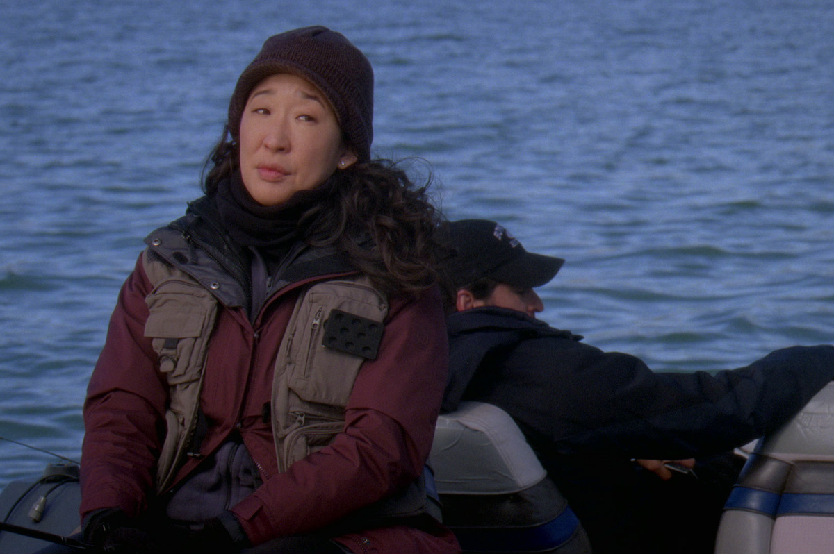Sandra oh looks impatient while sitting in a boat. 