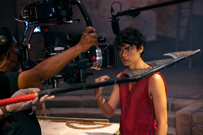 Iñaki Godoy as Monkey D. Luffy filming a scene with a weapon on set of Season 1 of 'One Piece.'