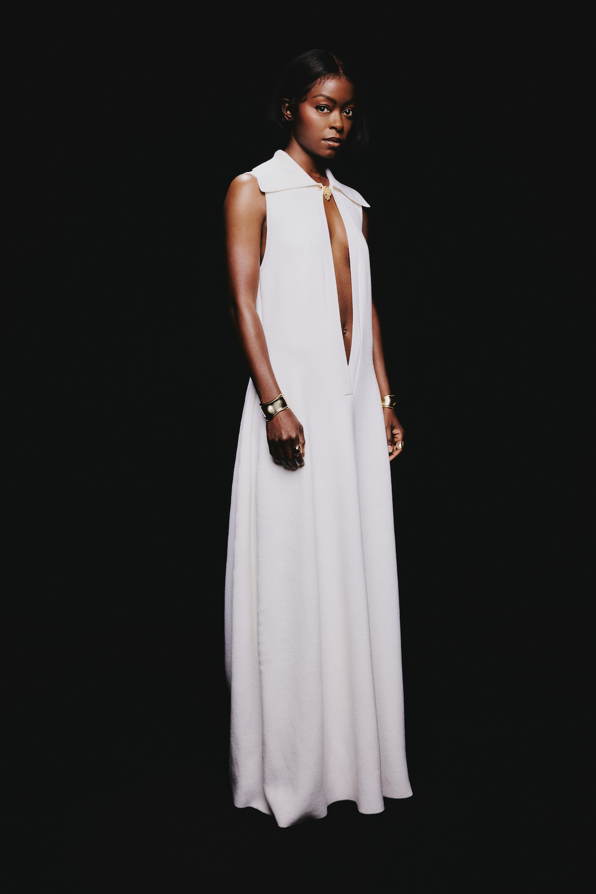 Danielle Deadwyler in a wears a white dress against a black background.