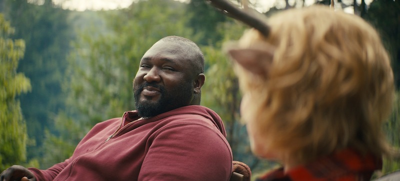 Nonso Anozie as Jepperd and Christian Convery as Gus sit together smiling in Season 3 of 'Sweet Tooth'
