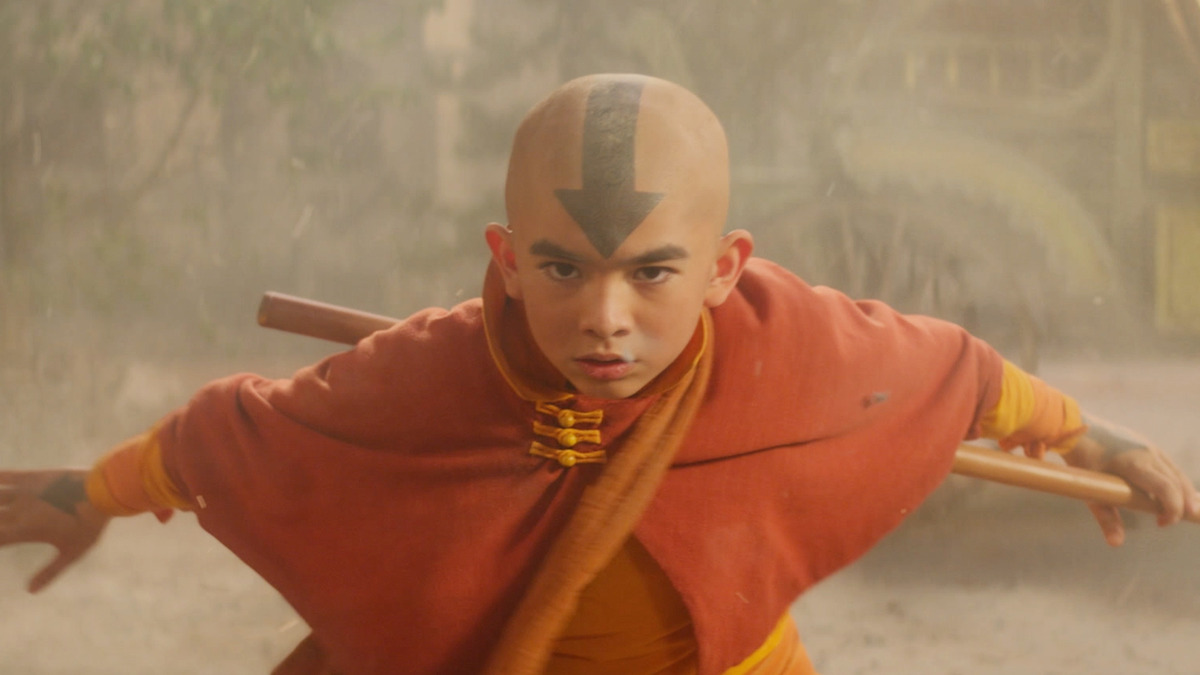 Gordon Cormier as Aang wears an orange cloak and holds a staff in season 1 of 'Avatar: The Last Airbender'
