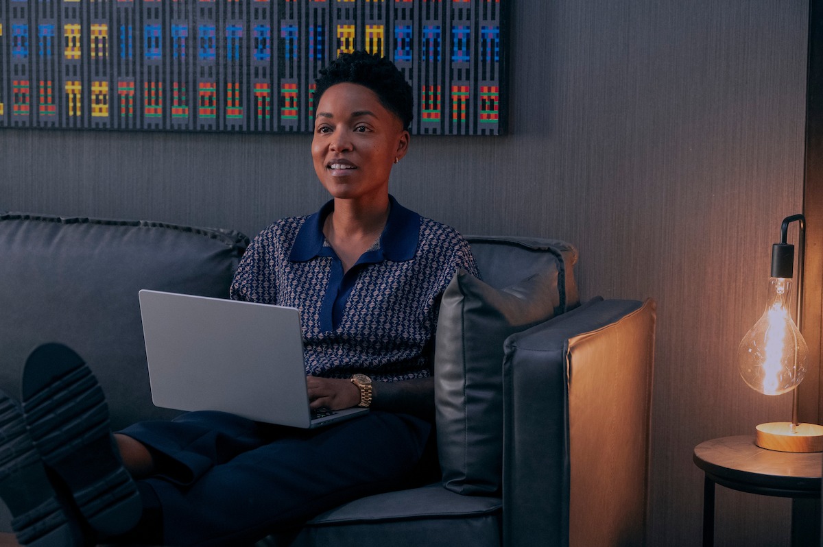 Ayesha Harris as Britt in ‘Glamorous’ Season 1 sitting with laptop.