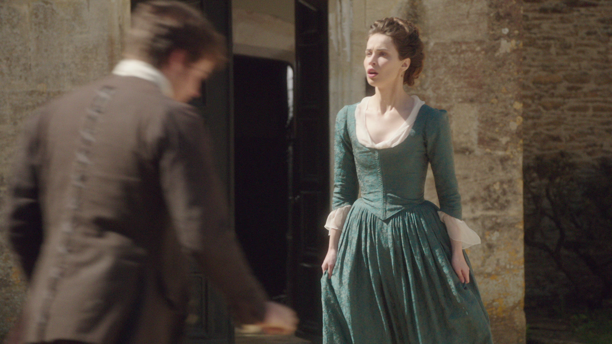 Heida Reed as Elizabeth stands in the courtyard in ‘Poldark.’