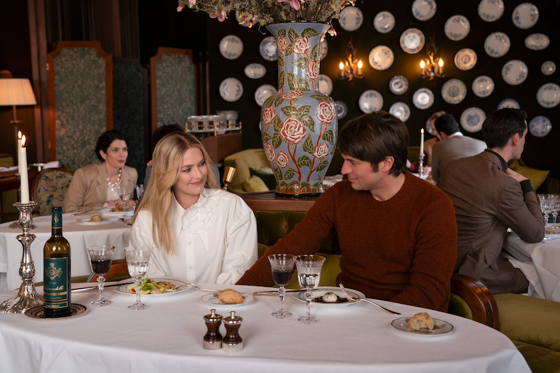 Camille Razat as Camille, Lucas Bravo as Gabriel sit in a restaurant together in Season 4 of 'Emily in Paris'