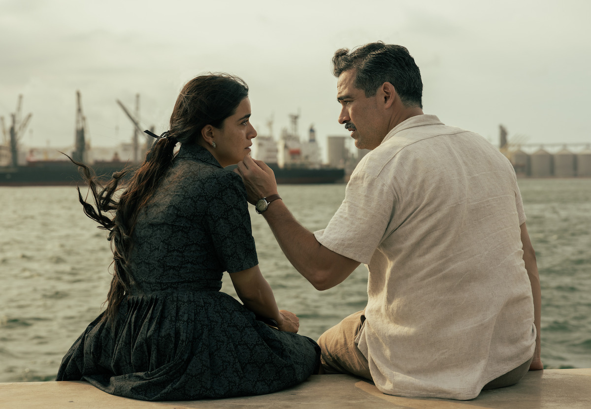 Paulina Gaitán as Serafina and Alfonso Herrera as Simón share a romantic moment by the water in a production still from ‘The Dead Girls.’