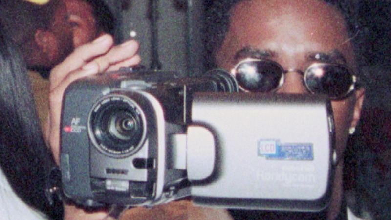A man holds a digital video camera.