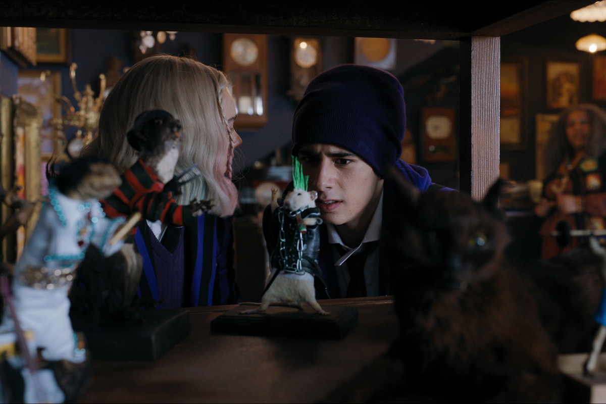 Emma Myers as Enid and Georgie Farmer as Ajax looking at mice in a taxidermy shop in ‘Wednesday’ Season 1.