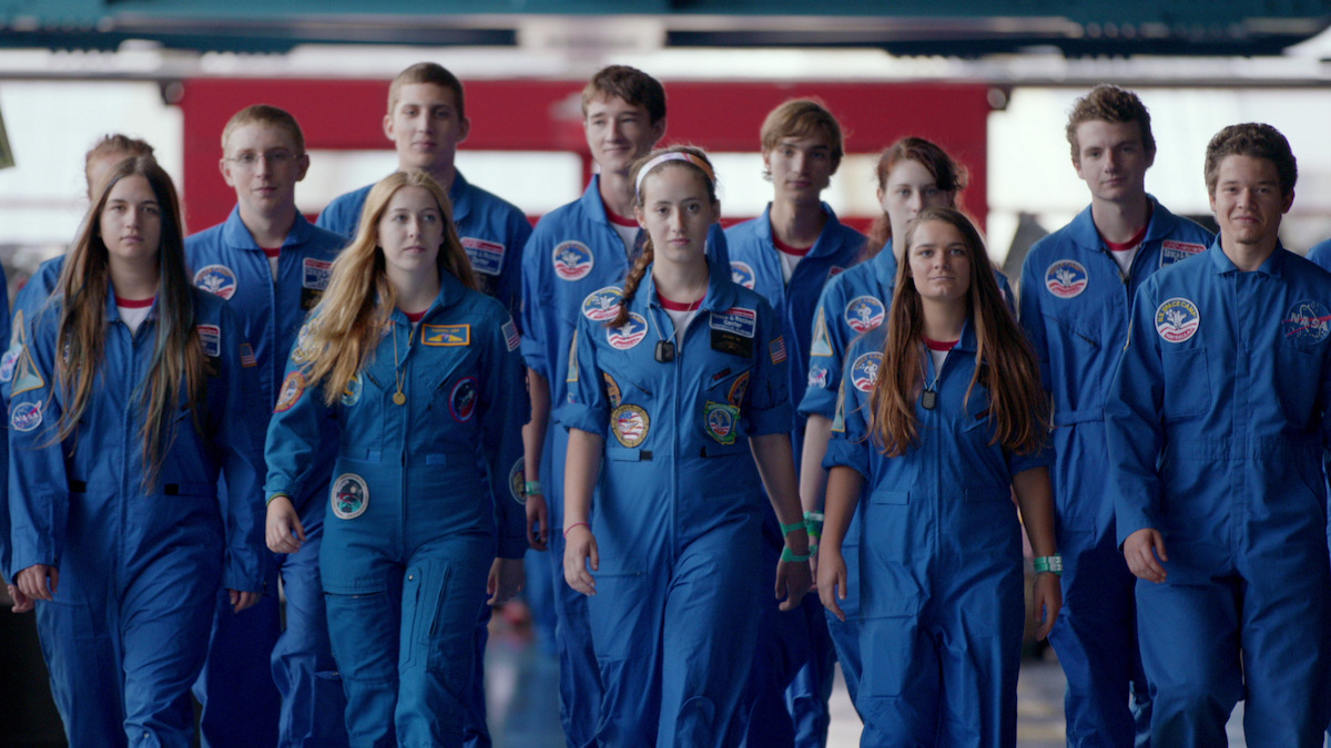 A group of young people walking together wearing flight suits