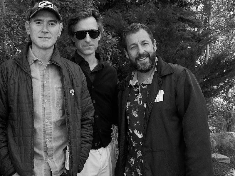 Billy Crudup, who wears a baseball cap, Noah Baumbach, who wears sunglasses, and Adam Sandler, who wears a printed shirt and black jacket.