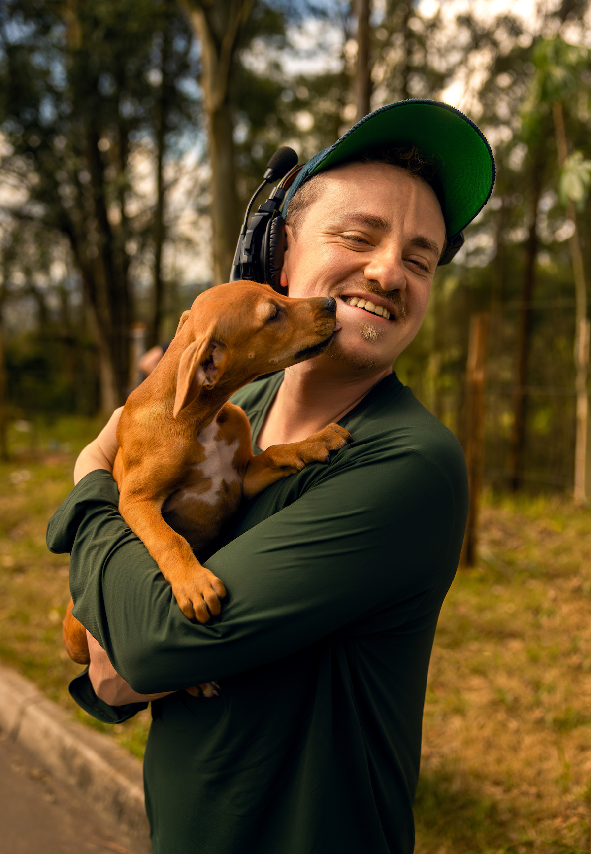 Homem abraça um cachorro caramelo no set de filmagem