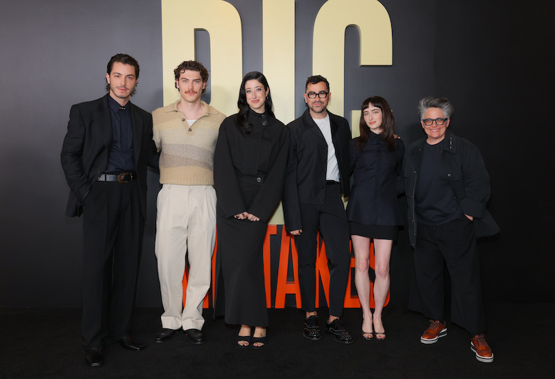 A group of six people pose against a background that says Big.