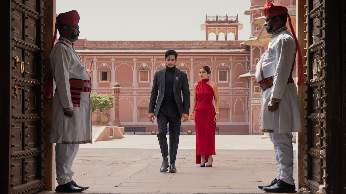 Ishaan Khatter as Aviraaj Singh and Bhumi Pednekar as Sophia Shekhar walk through palace grounds as guards stand nearby in ‘The Royals.’