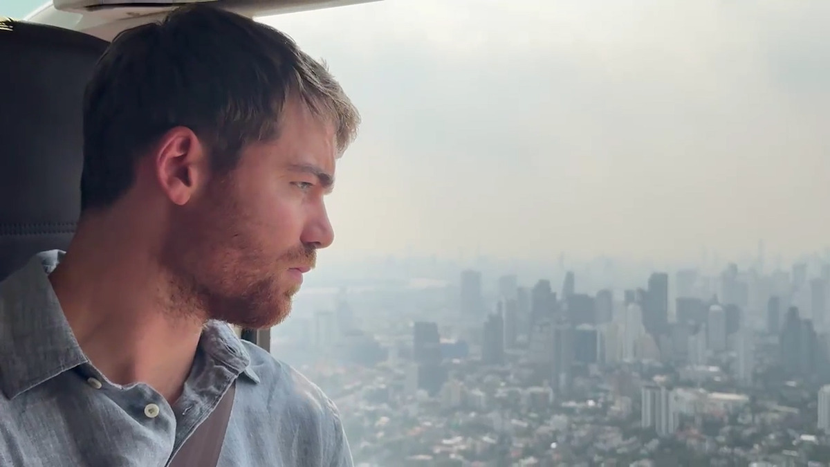 Gabriel Basso looks out of a helicopter during the filming of season 2 of 'The Night Agent'