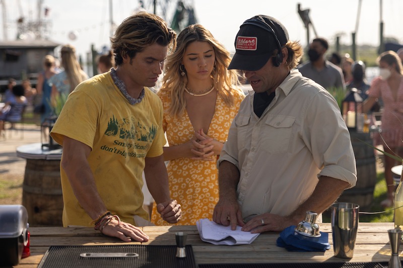Chase Stokes as John B, Madelyn Cline as Sarah Cameron and Director Jonas Pate in Outer Banks Season 3 Behind-the-Scenes Photo Gallery