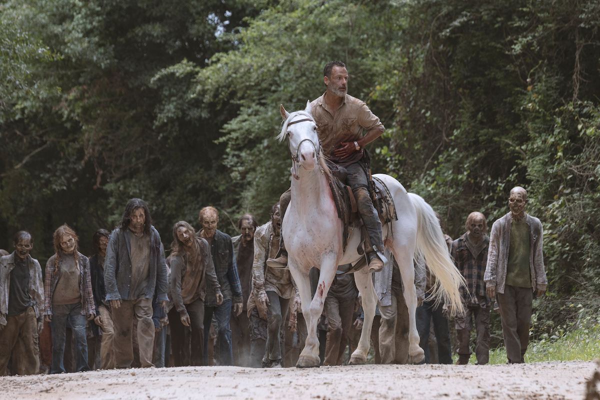 Rick on a horse leading a group of zombies
